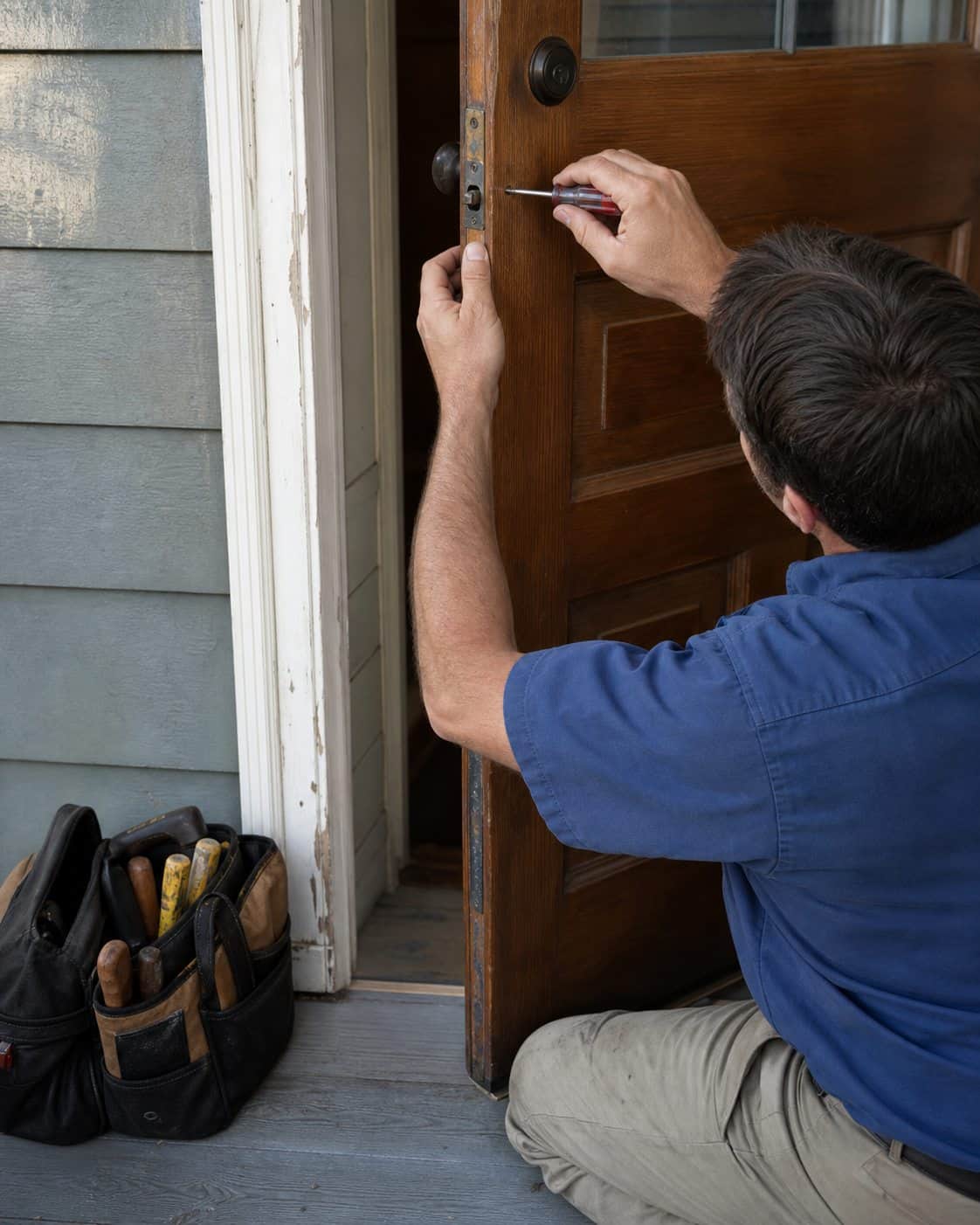 Home-maintenance professional carefully repairing an exterior door